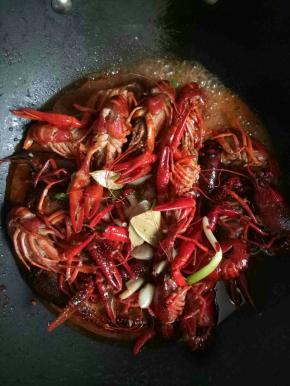 倒入小龙虾，加入少了的水，差不多和小龙虾平齐的位置，加1小勺盐，大火烧开，等水烧干到虾一半高的位置即可关火，翻炒几下，利用锅的余热，焖一会儿即可