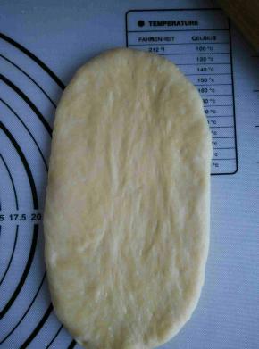 取一个面团，轻轻拍扁用擀面杖擀成椭圆形