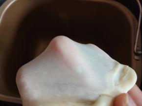 将吐司部分的所有食材以先液体后粉类的顺序放入面包机搅拌，揉至出手套膜，揉圆后进行第一次发酵