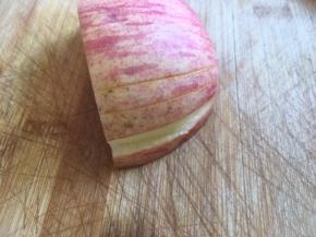 取比较大的那一块，用刀在苹果的表面划两条线