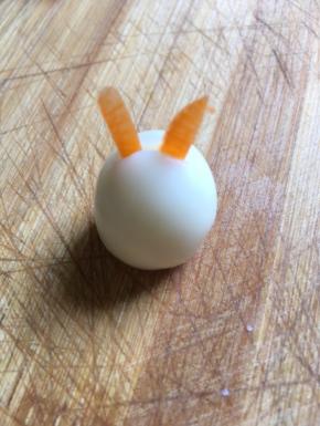 用刀在鹌鹑蛋顶部切一下，胡萝卜用剪刀剪出兔子的耳朵
