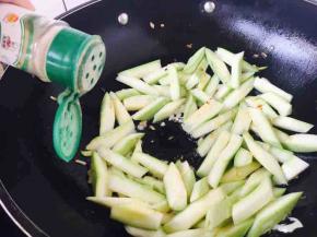 放入西葫芦条，翻炒几下，倒入少许白胡椒粉，再翻炒几下。
这时油温升高，请转中火。
