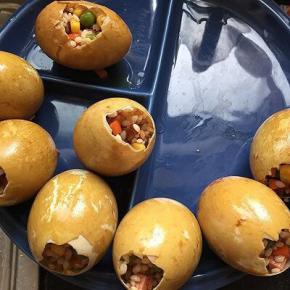 把腌好的糯米馅填入鸭蛋中，八九分满