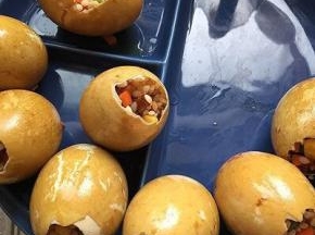 把腌好的糯米馅填入鸭蛋中，八九分满