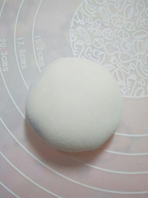 将面皮放掌心，慢慢将口收紧，拍适量度熟糯米粉防粘