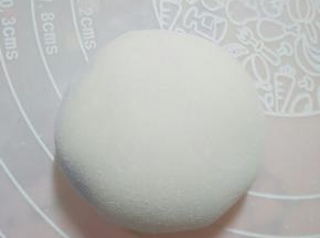 将面皮放掌心，慢慢将口收紧，拍适量度熟糯米粉防粘