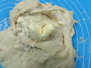 6. 这时把事先软化的黄油加入，继续揉搓，刚开始加黄油“惨不忍睹”