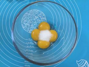 3. 在蛋黄糊中加人细砂糖，用手动打蛋器搅拌