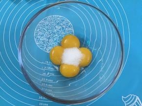 3. 在蛋黄糊中加人细砂糖，用手动打蛋器搅拌
