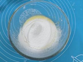 5. 把低筋面从距离盆口10厘高的位置筛入到蛋黄糊中，搅拌至看不见干粉