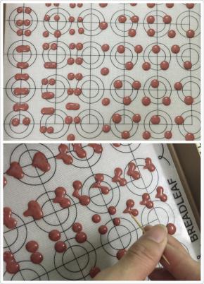 11. 拿一个小杯子把裱花袋套花，这样倒面糊时就可以避免手忙脚乱的，装好的面糊，裱花袋剪一个小口，千万别剪太大哦，在烤盘上挤出你想要做的形状，挤两个小圆点，再用牙签来辅助分别从圆形下方用牙签往中间划动，这就成为一个心形啦,一个蛋糕卷可以画俩到三个图案