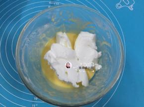 7. 将三分之一的蛋白霜倒入蛋黄糊中，用手动打蛋器从底部向上拌起，拌至顺滑细腻的程度