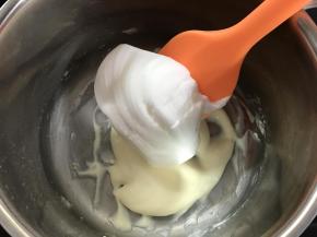 5、先取1/3蛋白霜和香蕉奶粉糊切拌均匀。