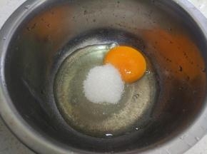 鸡蛋打入盆中，加入25克细砂糖。