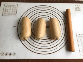 两边按压出气泡，卷起。盖上保鲜膜继续松弛15分钟