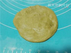 取1个面团，收口朝下。用手拍扁排气，擀成圆形。