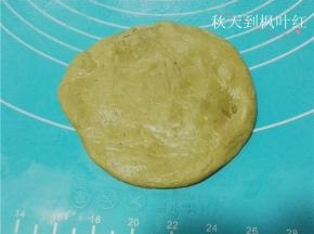 取1个面团，收口朝下。用手拍扁排气，擀成圆形。
