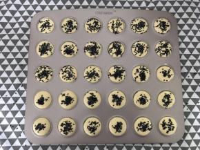 均匀的挤在马卡龙烤盘上。没有这种烤盘也可以挤在普通烤盘中，挤圆形，留出空隙。撒上黑芝麻。
撒多了，密集恐惧症者慎入