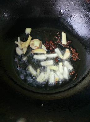 6、	加入葱段和姜片，炒出香味。