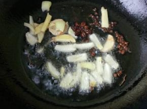 6、	加入葱段和姜片，炒出香味。