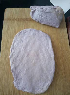 把面团平均分成2份，取一份用擀面杖轻轻的擀成接近长方形的面片（不要用力排气）。