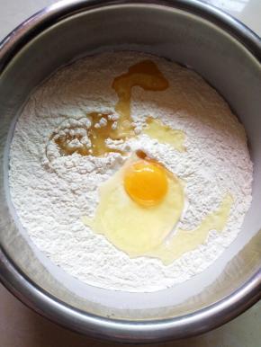 把面粉倒入盆里,加入橄榄油和鸡蛋,面粉吸水性不同,水酌情加入。