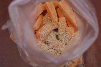 2.放入塑料袋里倒入植物油和白芝麻混合均匀