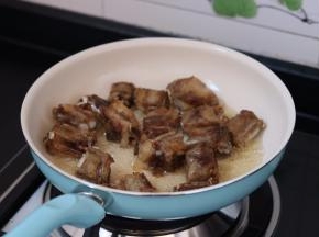 4.放入排骨小火两面煎黄