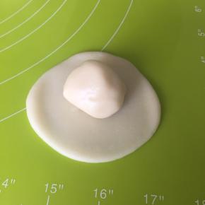 取一个水油皮面团，压扁擀圆，包入一个油酥