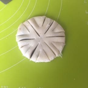 反过来压到1cm厚的圆饼，先用刀轻轻划分为6份，再顺着印子切下（注意不要切断，中间要留着不切），再在每一份中间切两刀较短的口，如上图