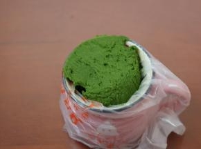 4.筛入低筋面粉和抹茶粉混合均匀至看不到面粉
裱花嘴放入裱花袋中，将裱花袋套在杯子中装入面糊，用刮刀将面糊推向裱花嘴的位置