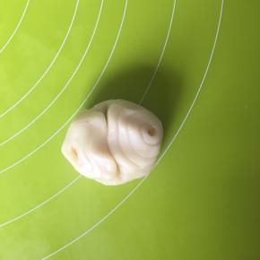 取一个面卷从中间向上对折，压扁