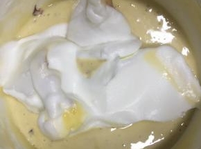 再取1/3的蛋白霜到均匀的蛋糕糊中，继续翻拌均匀