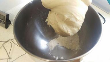 发酵好的面团拿出来放回厨师机里面加入15g面粉，和2-3g水，用低速揉到盆光，面团会吸收全部的面粉。用手就慢慢把粉揉进面团里面，面粉太干就加点点水，不能太多。