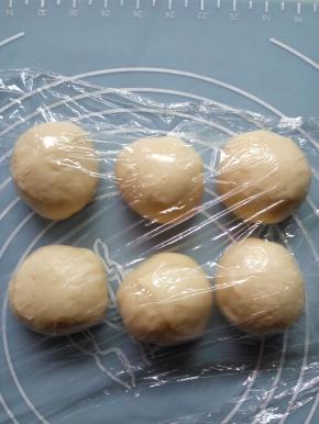 把面团按压排气，平均分成6等份，盖保鲜膜醒面25分钟。