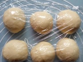 把面团按压排气，平均分成6等份，盖保鲜膜醒面25分钟。