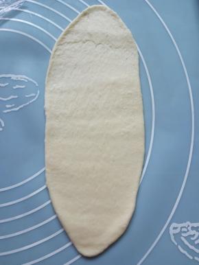 取一个面团擀成长橄榄形，越长越好。