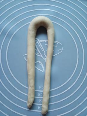 取一个面团搓成细长条，最好40厘米长，然后对折过来。