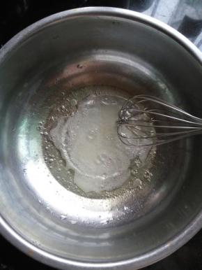 A先做戚风蛋糕：玉米油、水和30克细砂糖放入盆里，用手动打蛋器搅拌均匀，让油充分乳化。