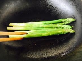 煎制时用筷子翻动芦笋，让芦笋受热均匀，当芦笋表皮略微发蔫时芦笋就熟了。
