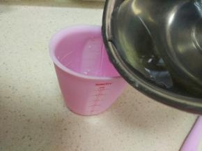 把搅拌好的糖水倒入杯子中。