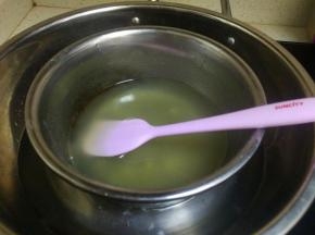 将勾兑的果冻水放在隔水加热。让果冻水溶解。