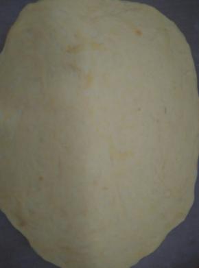 取出面团揉揉排气，擀成椭圆形面皮