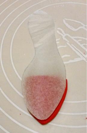 白色干佩斯加大红色素，揉匀后擀成厚为3豪米的厚片，按鞋垫鞋头的大小做好鞋子的防水台