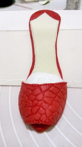 组装鞋底：浅黄鞋垫沾好防水台，沾了黄鞋垫的红色鞋底与沾了防水台的黄鞋型沾连。鞋面用尖形工具做出车线效果后与做好的鞋底沾连，用纸巾搓个圆型塞进鞋面内部定形