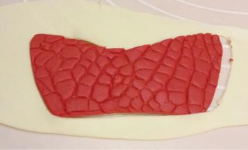 浅黄色干佩斯擀平，按红色鞋面大小再切好鞋里