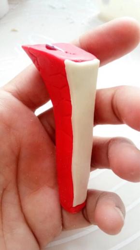 红色干佩斯捏成鞋跟造型，中间插入一根铁丝固定