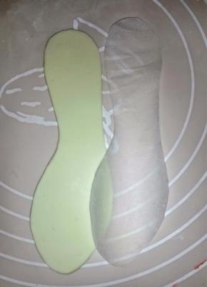 先用油纸画好鞋垫的大小，用剪刀剪好。白色干佩斯加少许黄色揉匀，擀平，按鞋垫纸垫切好2片