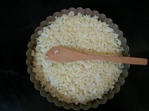 1.将鸡蛋打散倒入米饭中搅拌均匀，让每一粒米饭都沾上鸡蛋液，铺到烤盘上