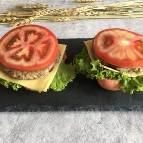 面包胚切开，底部放上一片生菜叶、芝士片、牛肉饼、番茄